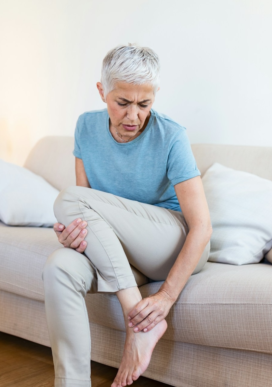 woman with foot discomfort on couch